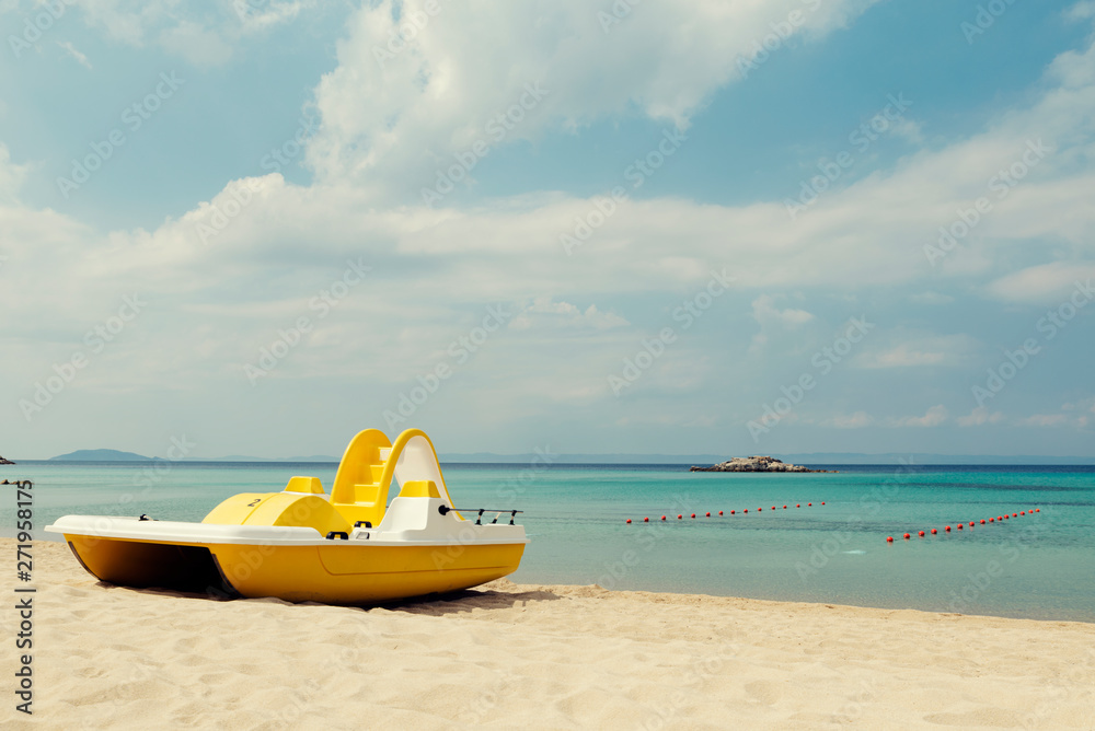 Yellow pedal boats on a turquoise beach in Greece and lines with red buoys Selective focus Yellow pedal boats on a turquoise beach in Greece and lines with red buoys Selective focus