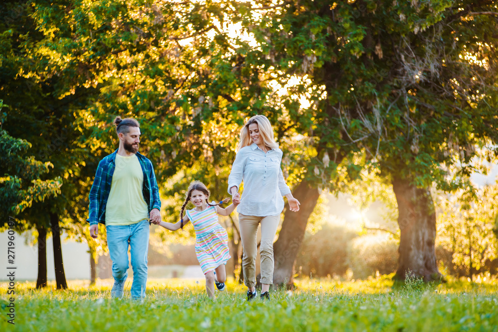 Fototapeta premium Happy young family spending time together outside in green nature.