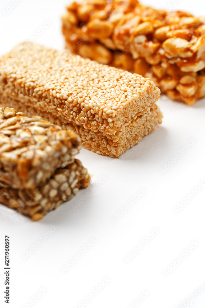 Grain granola bar with peanuts, sesame and seeds in a row on a white background. Top view Three assorted bars, isolate Grain granola bar with peanuts, sesame and seeds in a row on a white background. Top view Three assorted bars, isolate