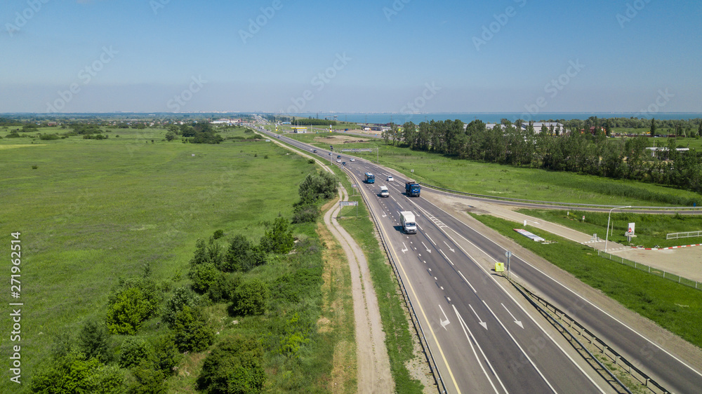 Aerial flying under highway traffic road with cars and truck