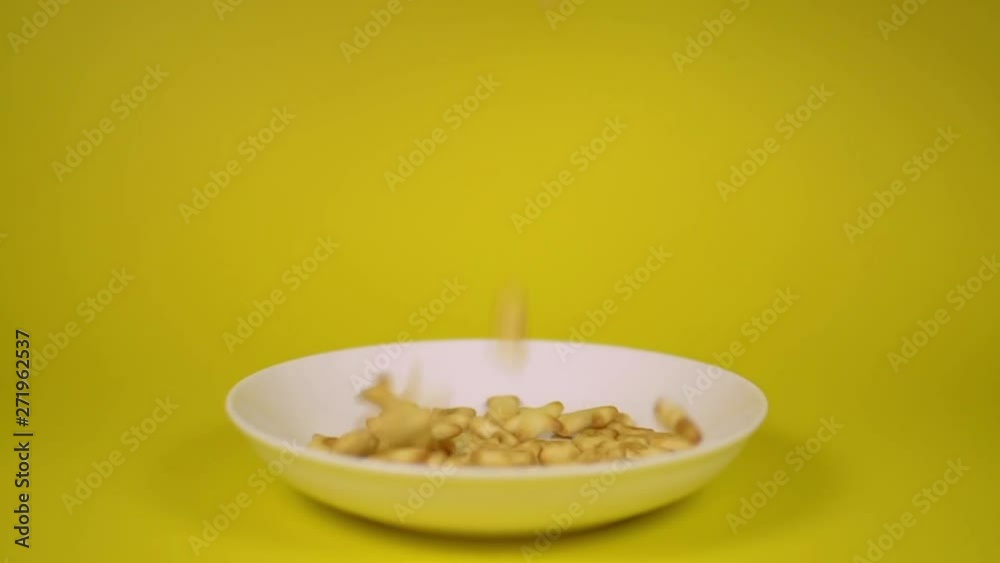 Cracker seafood shape are poured into a dish isolated on yellow background. Cracker seafood shape are poured into a dish isolated on yellow background.