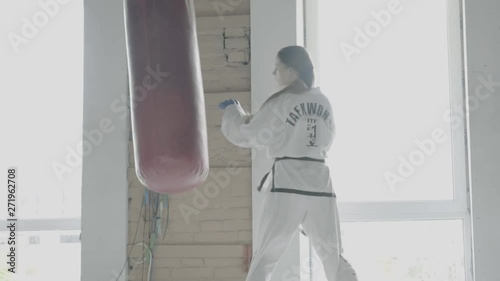Slow motion Taekwondo Girl Trains With Punching Bag In The Gym