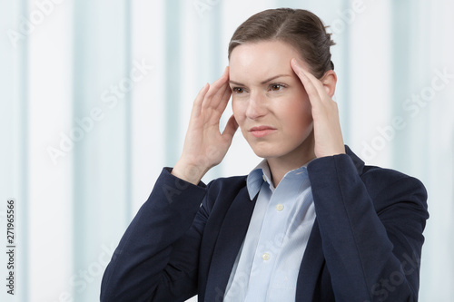 business woman has a headache in front of a office window