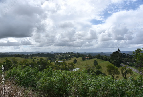 Broad panorama of the countryside on Sunshine Coast Hinterland. Grassy hills in the background. View from Kanyana Park on a cloudy day (Queensland, Australia).