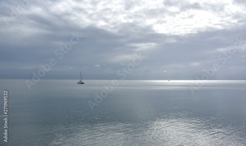 Gushing sea on a cloudy day. Horizontal view of dramatic overcast sky and sea. Fifty shades of blue and gray.