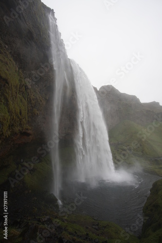 beautiful iceland waterfall with rocks and skies