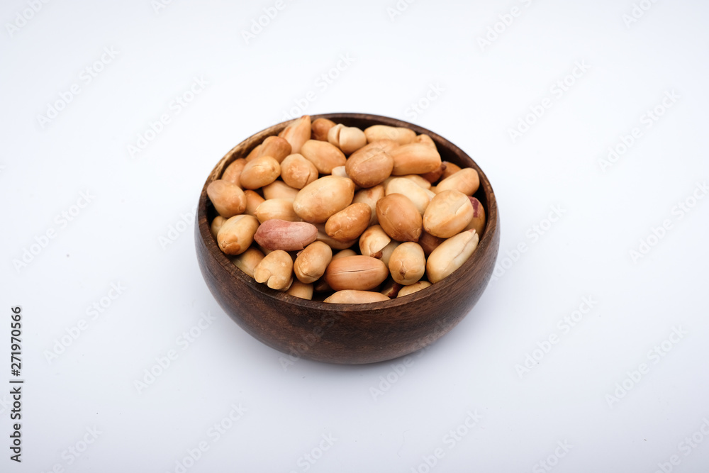 Roasted peanuts in wooden bowl, peanuts are on the isolated on white background Roasted peanuts in wooden bowl, peanuts are on the isolated on white background