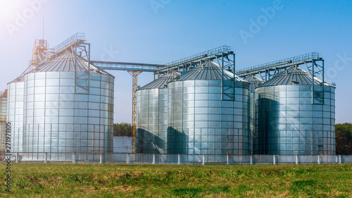 Φωτογραφία silver silos on agro manufacturing plant for processing drying cleaning and stor