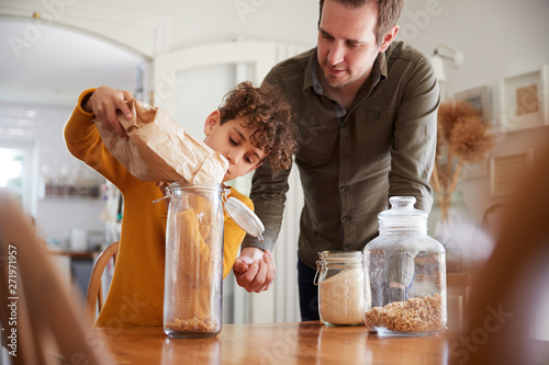 Father Helping Son To Refill Food Containers At Home Using Zero Waste Packaging photo