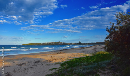 Panoramic landscape of Woolgoolga, Woolgoolga Headland and beach in New South Wales, Australia. People walking on the beach.