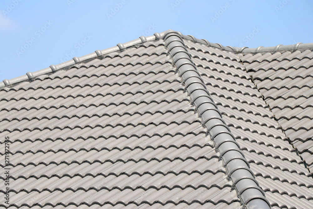 The roof tile with the sky background. The grey roman tile pattern. The roof tile with the sky background. The grey roman tile pattern.