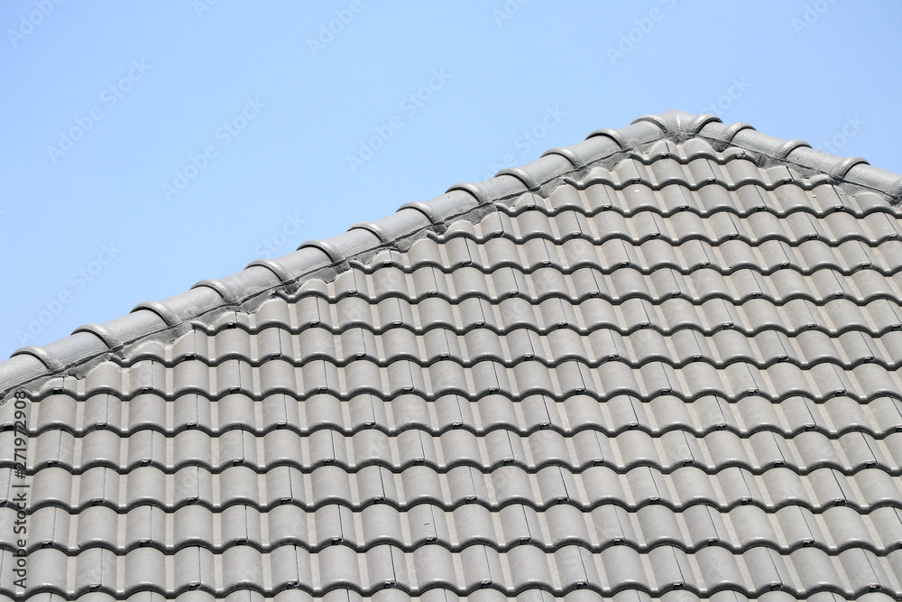 The roof tile with the sky background. The grey roman tile pattern. The roof tile with the sky background. The grey roman tile pattern.