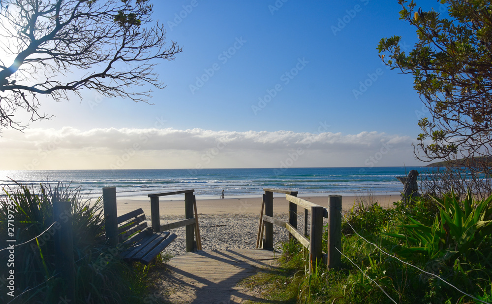 Old wooden walkway path entrance to the beach. Sandy ocean beach entrance. Sea beach wooden walkway path entrance. Sandy ocean beach entrance.