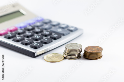 Calculator and coin on white background