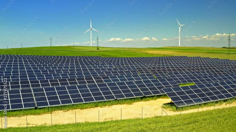 Solar Panels and wind turbines on green field with blue sky, aerial view, Poland Solar Panels and wind turbines on green field with blue sky, aerial view, Poland
