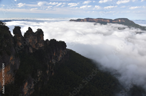 Three Sisters rock formation in the Blue Mountains National Park (NSW, Australia). Jamison Valley is full of with mist after a big rain, photo