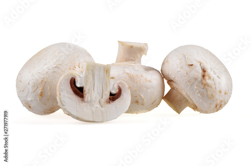 Fresh composition of whole and sliced champignon mushrooms on a neutral white background