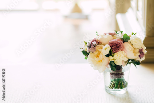 Gorgeous luxury wedding table arrangement, floral centerpiece close up. The table is served with cutlery, crockery and covered with a tablecloth. Wedding party decoration with pink and white flowers. photo