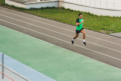 full length view of mixed race sportsman running at stadium