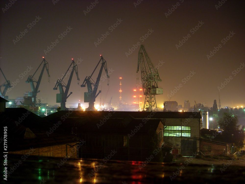 A night photograph of the Gdańsk Shipyard.