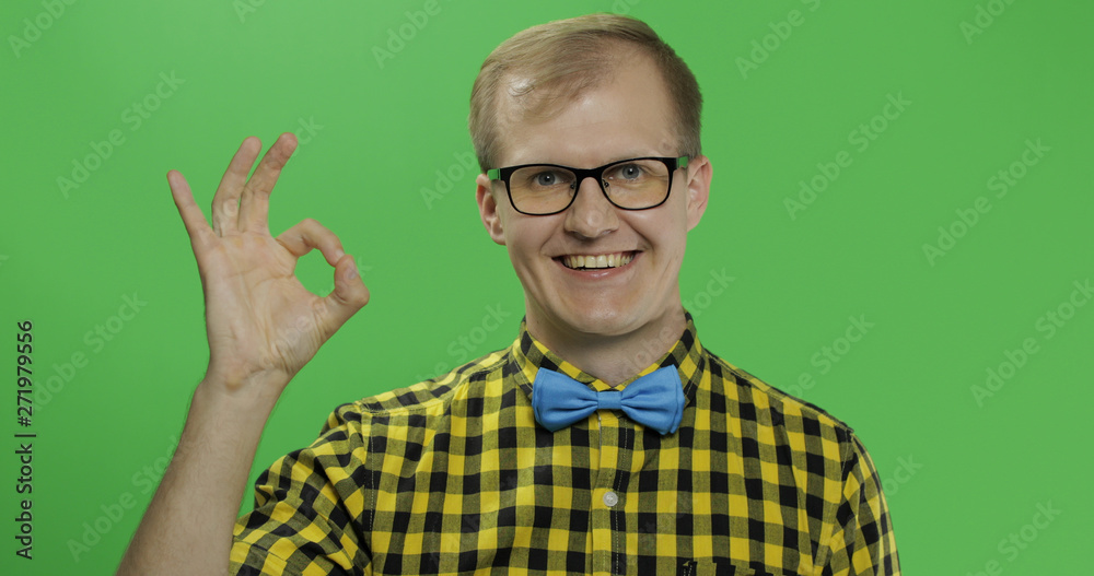 Caucasian man in glasses and yellow shirt showing OK gesture. Chroma key