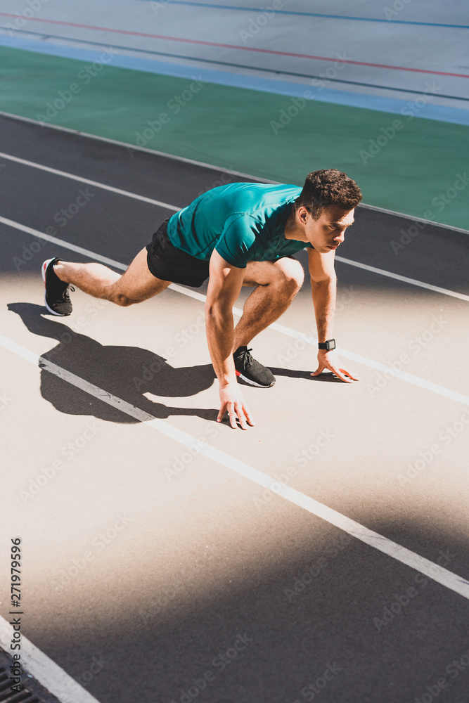 mixed race sportsman on start position at stadium mixed race sportsman on start position at stadium