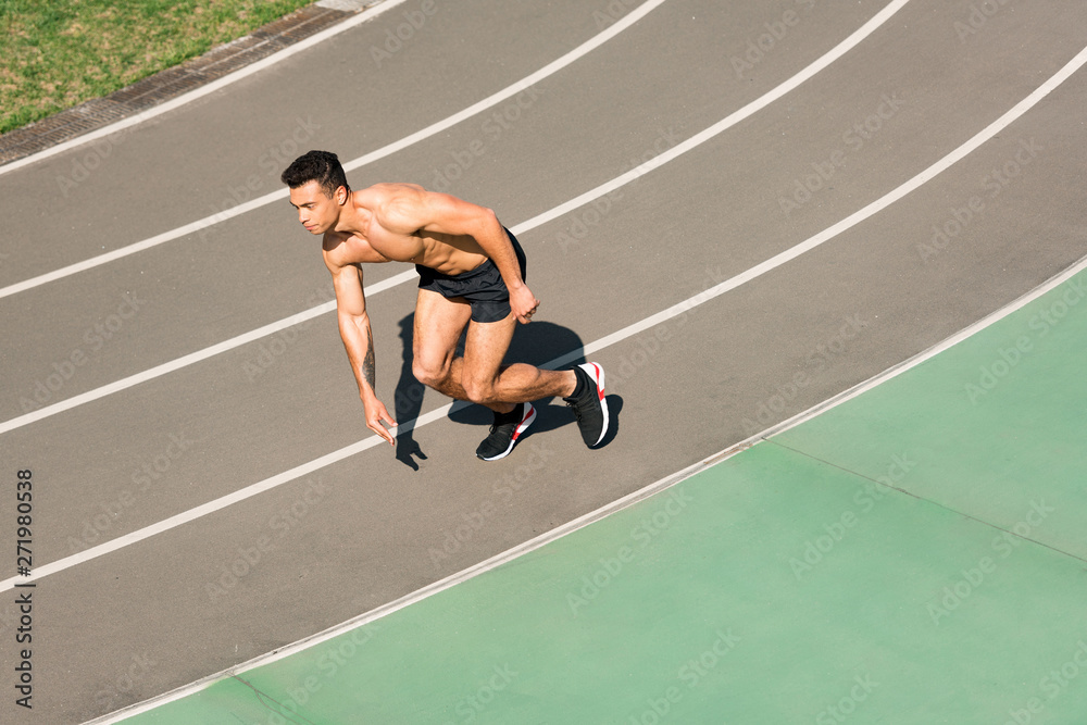 Obraz premium overhead view of mixed race sportsman running at stadium