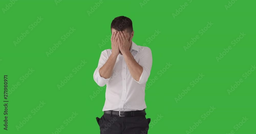 Bankrupt businessman pulling out his empty pockets and crying out loud over green background