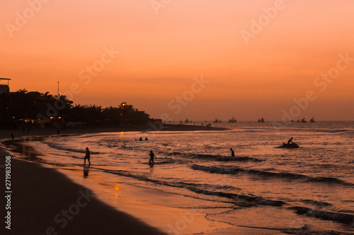 sunset over mancora beach with fisher boats, peru