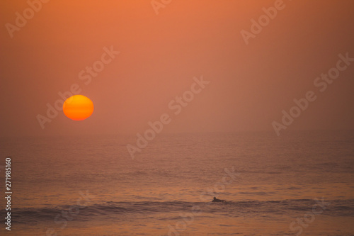 Fototapeta Naklejka Na Ścianę i Meble -  sunset over the ocean with a surfer in huanchaco, peru
