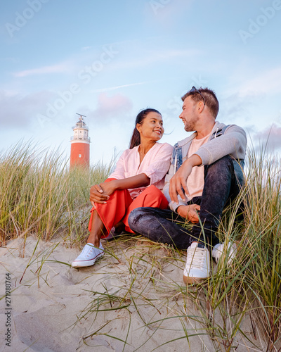 couple lighthouse Texel Netherlands, men and woman on vacation Dutch Island texel