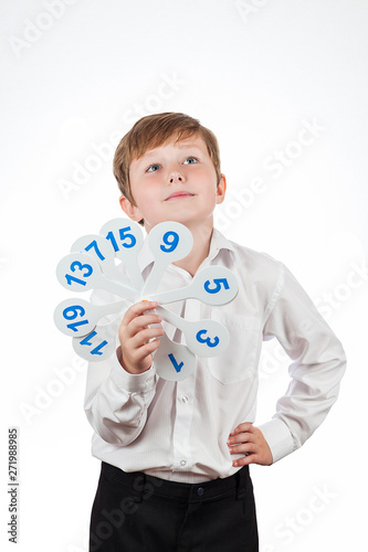 schoolboy in a white shirt holding a set for mathematics