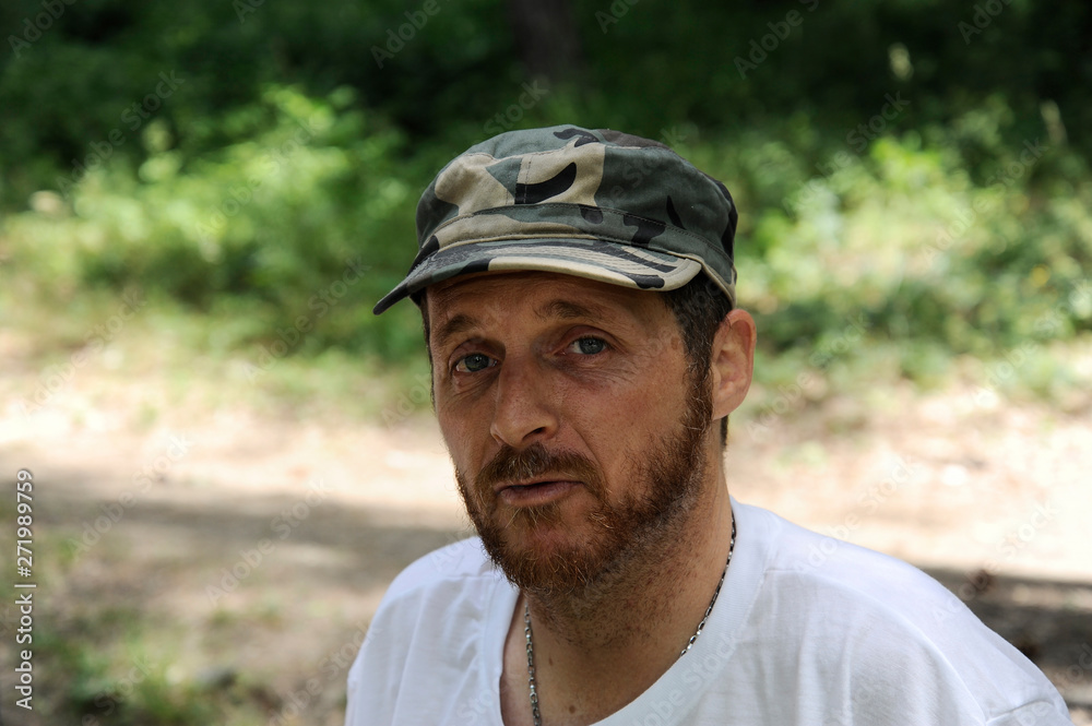 Outdoors horizontal portrait of happy hiker young man with red beard, feel good after hiking in forest. Traveler bearded male smiling and feel happy during trekking in his journey. Travel, lifestyle