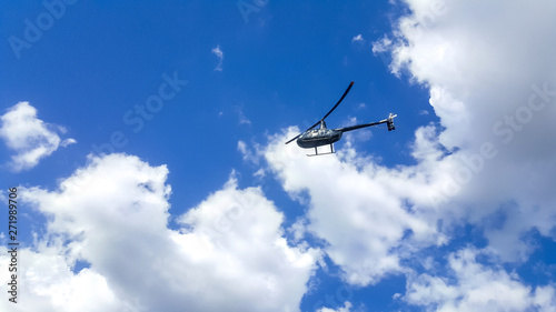 Fototapeta Naklejka Na Ścianę i Meble -  helicopter flying blue cloud wallpaper