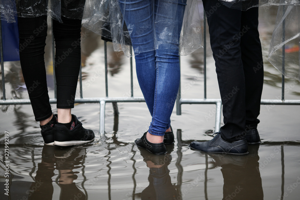 Details with the feet of young people standing in water at a public gathering (music festival) Details with the feet of young people standing in water at a public gathering (music festival)
