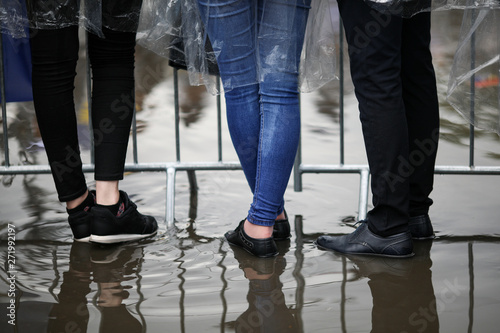 Details with the feet of young people standing in water at a public gathering (music festival)