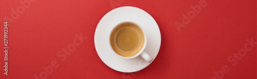 top view of white cup with coffee on saucer on red background  panoramic shot