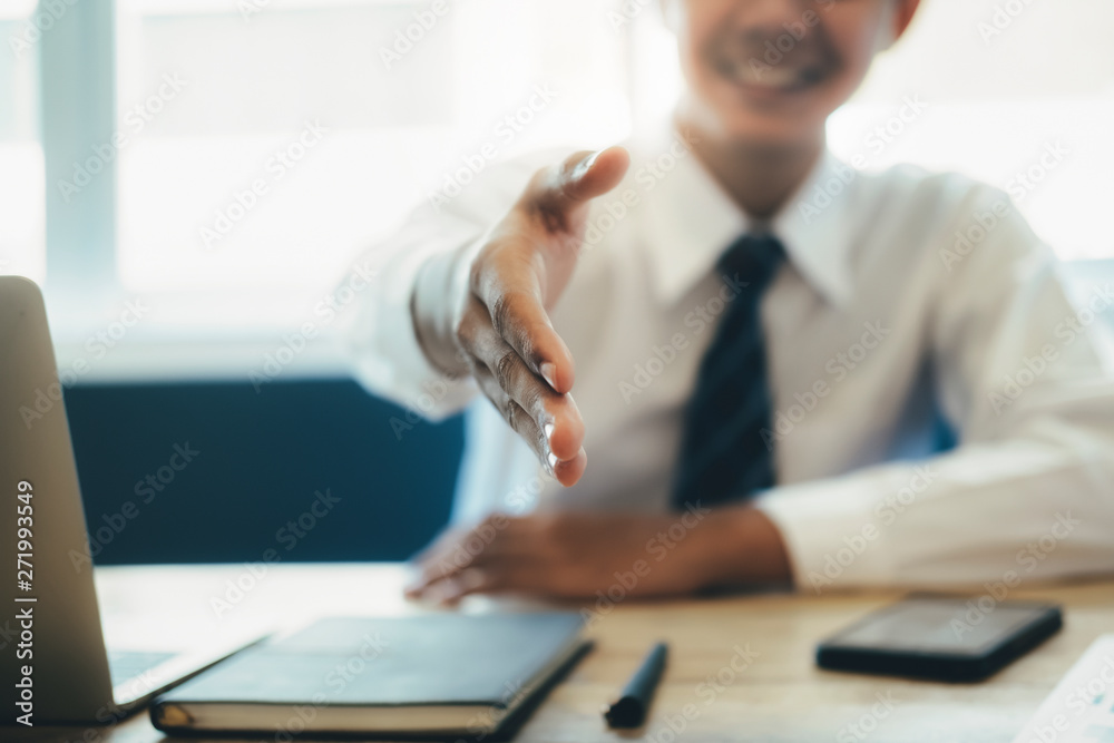 Young Asian businessman extending his arm in a handshake. Young Asian businessman extending his arm in a handshake.