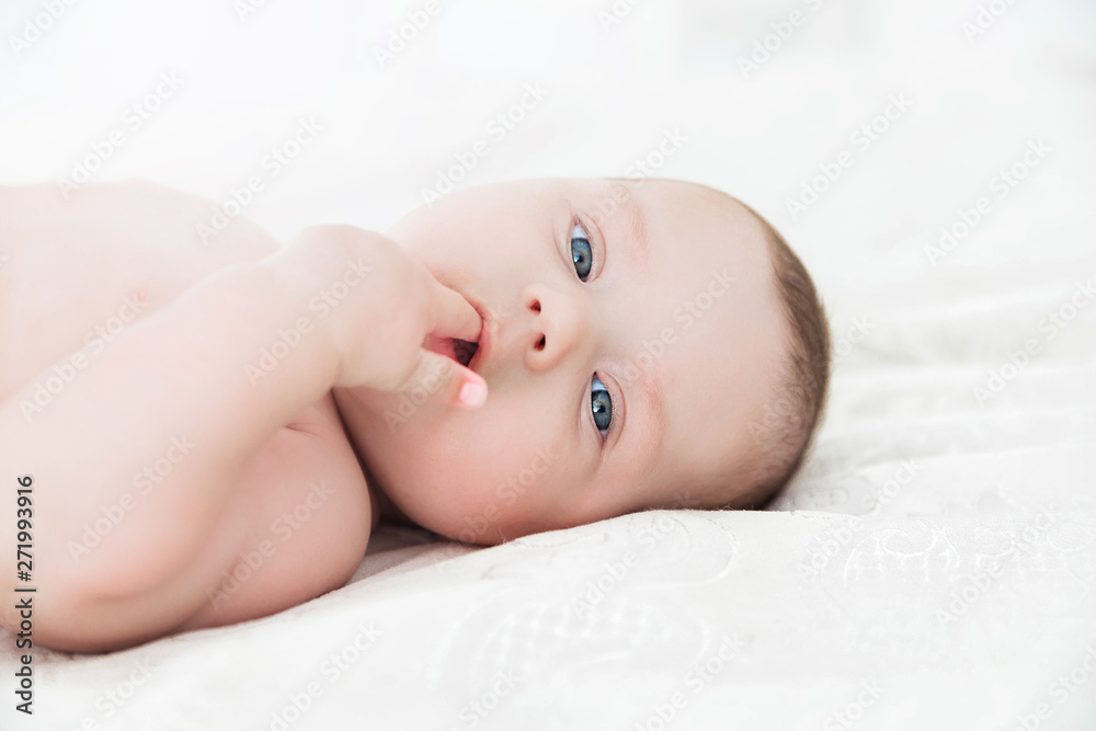Portrait of a baby lying on a white bed Portrait of a baby lying on a white bed