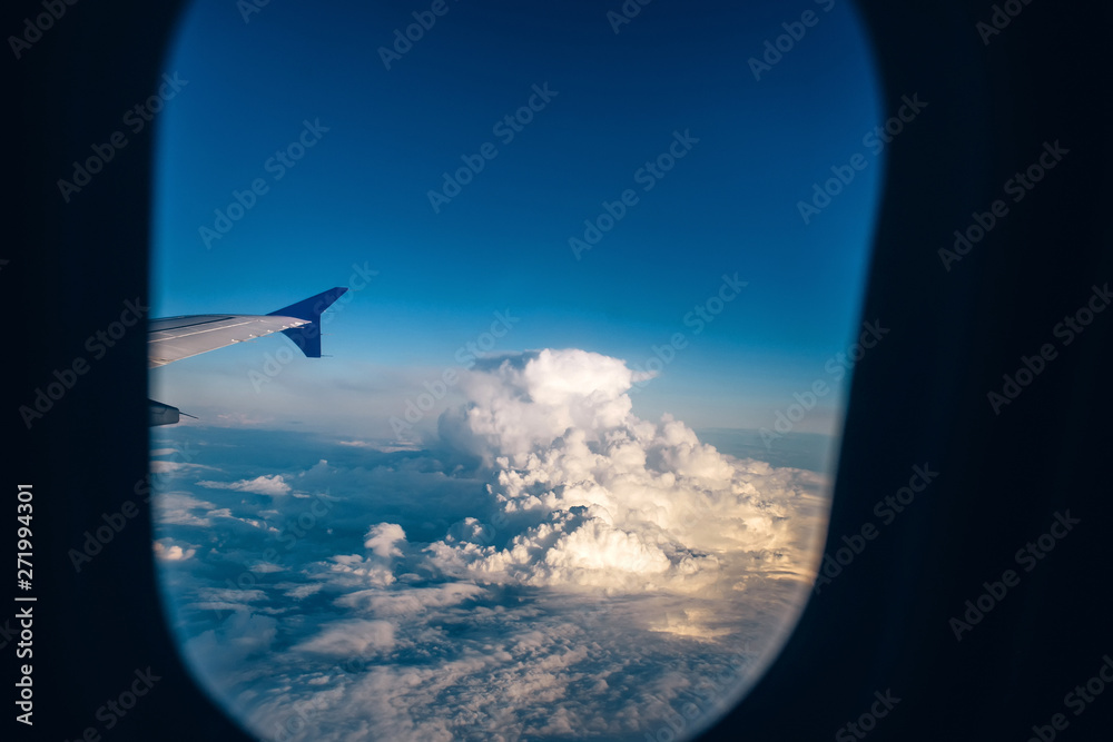 wing of the plane against the blue sky with clouds. view from eluminator to the wing of the aircraft against the sky. Concept: flight, vacation, tourism. wing of the plane against the blue sky with clouds. view from eluminator to the wing of the aircraft against the sky. Concept: flight, vacation, tourism.