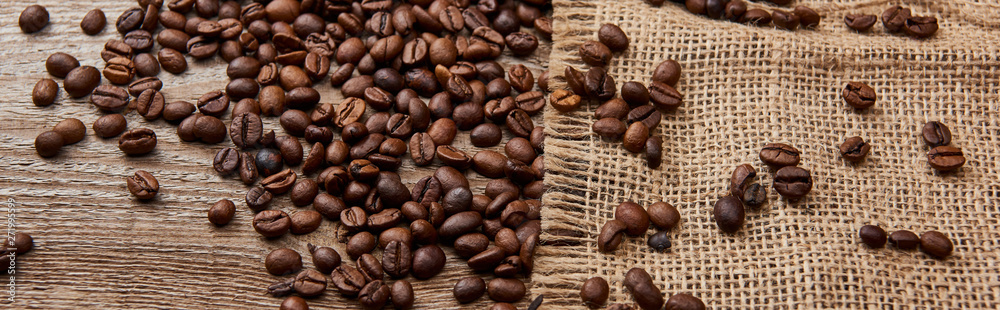 panoramic shot of fresh roasted coffee beans on wooden weather board with sackcloth panoramic shot of fresh roasted coffee beans on wooden weather board with sackcloth