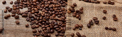 panoramic shot of fresh roasted coffee beans on wooden weather board with sackcloth