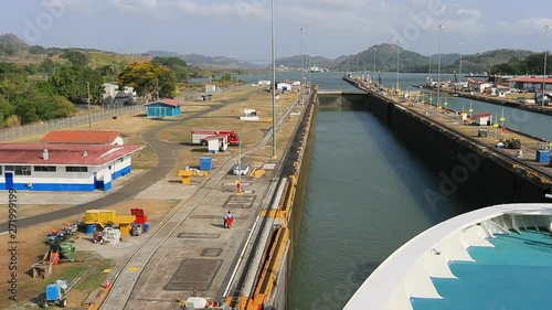 Panama Canal cruise ship in locks POV fast motion. The Panama Canal locks system lifts a ship up 85 feet and down again between the Atlantic and Pacific Ocean. 52 miles long. Engineering industrial. photo