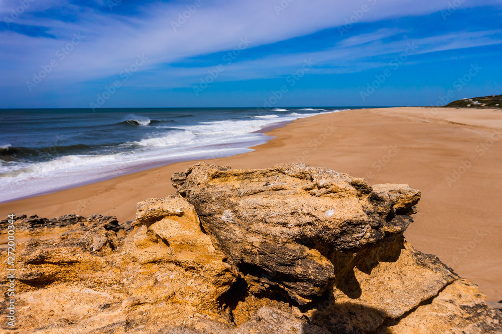 rock on beach in Nazare on Atlantic coast with ocean wave
