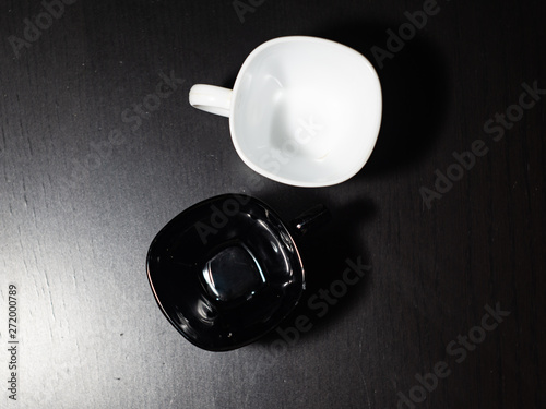 Black and white mugs on a black table