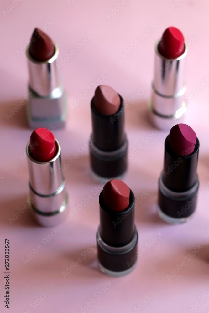 Collection of lipsticks in red, mauve and nude colors on pink background. Selective focus. Collection of lipsticks in red, mauve and nude colors on pink background. Selective focus.