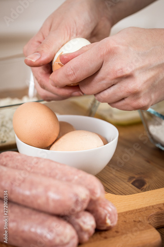 Frau pellt Eier für Scotch Eggs in Schweine Fleisch Wurstbrät und Paniermehl 
