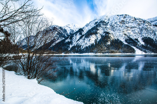 Bright green waters of winter lake and mountains  reflected in the water  Bayern  Germany. 