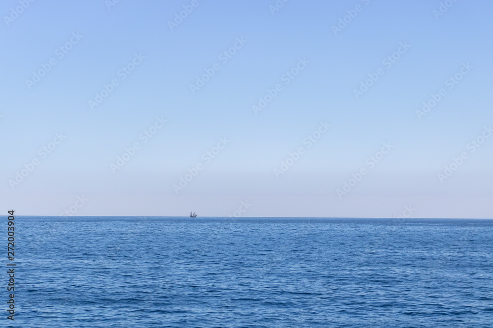 Seascape with sea horizon and almost clear deep blue sky