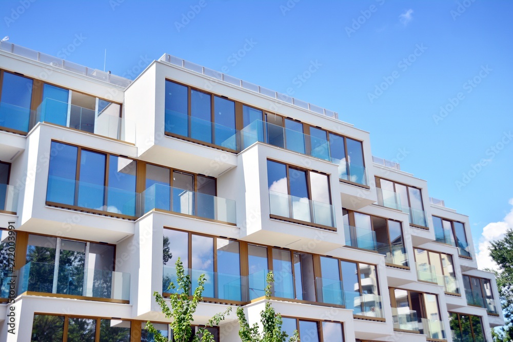 Fototapeta premium Modern apartment buildings on a sunny day with a blue sky. Facade of a modern apartment building